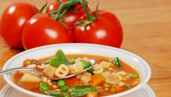 vegetable soup with tomato in the background