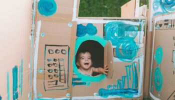 A happy baby in a painted cardboard box.