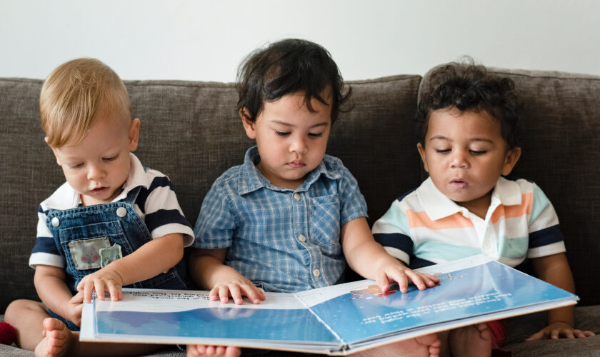 Three,Little,Boys,Reading,A,Book,On,A,Sofa