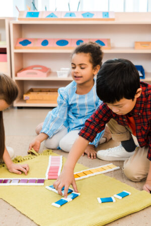 Children,Playing,Educational,Game,On,Floor,In,Montessori,School