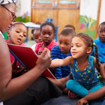 Teacher,Reading,A,Book,With,A,Class,Of,Preschool,Children