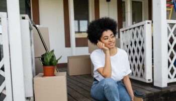 Pleased,African,American,Woman,Holding,Coffee,To,Go,While,Sitting