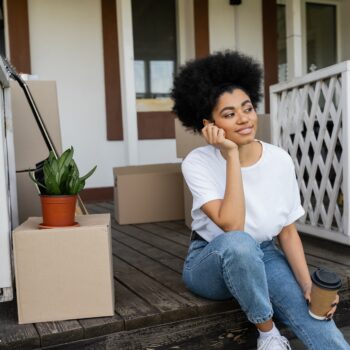 Pleased,African,American,Woman,Holding,Coffee,To,Go,While,Sitting