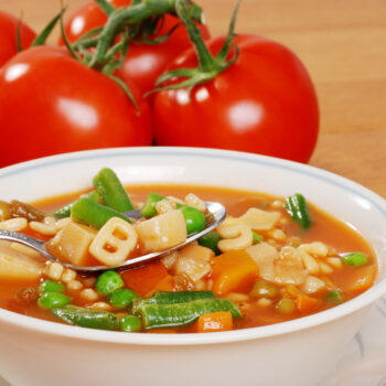 vegetable soup with tomato in the background
