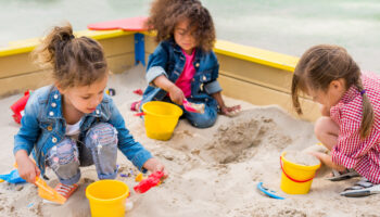 Three,Multiethnic,Little,Children,Playing,With,Plastic,Scoops,And,Buckets